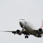 white and red airplane under white sky during daytime