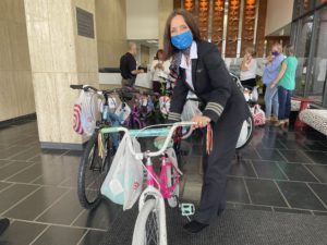 First Officer Lorrie LeBlanc helps move a donated bicycle at the American Airlines Flight Academy in Dallas-Fort Worth.