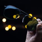 person holding green and black sunglasses