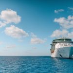 white and blue ship on sea under blue sky and white clouds during daytime