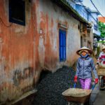 two women walking beside orange house