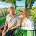 Couple travelling over the rainforest canopy in a gondola