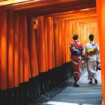 Two,Woman,Walking,Through,Famous,Lines,Of,Orange,Column,Tori
