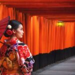 Woman in traditional Japanese kimono walking at Fushimi Inari Shrine in Kyoto