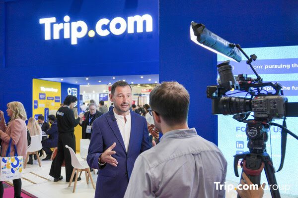 Mr Andy Washington, General Manager for Europe, is taking interviews at the Trip.com Group booth