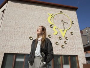 Artist Outi Pieski in front of the Keski-Pasila primary school and daycare, where her work ČSV áigi was installed in 2025. Photo Maija Toivanen, HAM Helsinki Art Museum