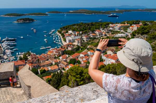 Female Tourist taking photos of Hvar island from the fortress. Dalmatian coast, Croatia, Europe