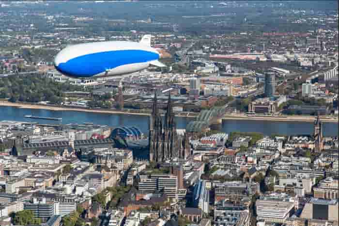 A Zeppelin airship in flight over Cologne as part of the Zeppelin Flight Over Cologne shore excursion, one of several new experiences available on select Rhine River itineraries