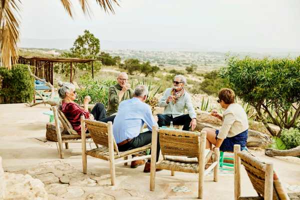Wide shot of senior friends on patio during vacation in Morocco