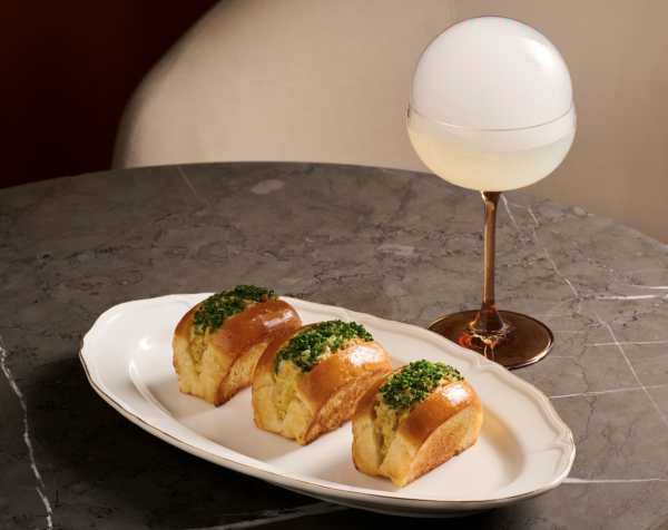 The “Sun-Kissed Crab” bite is served with the Midnight Fizz Society